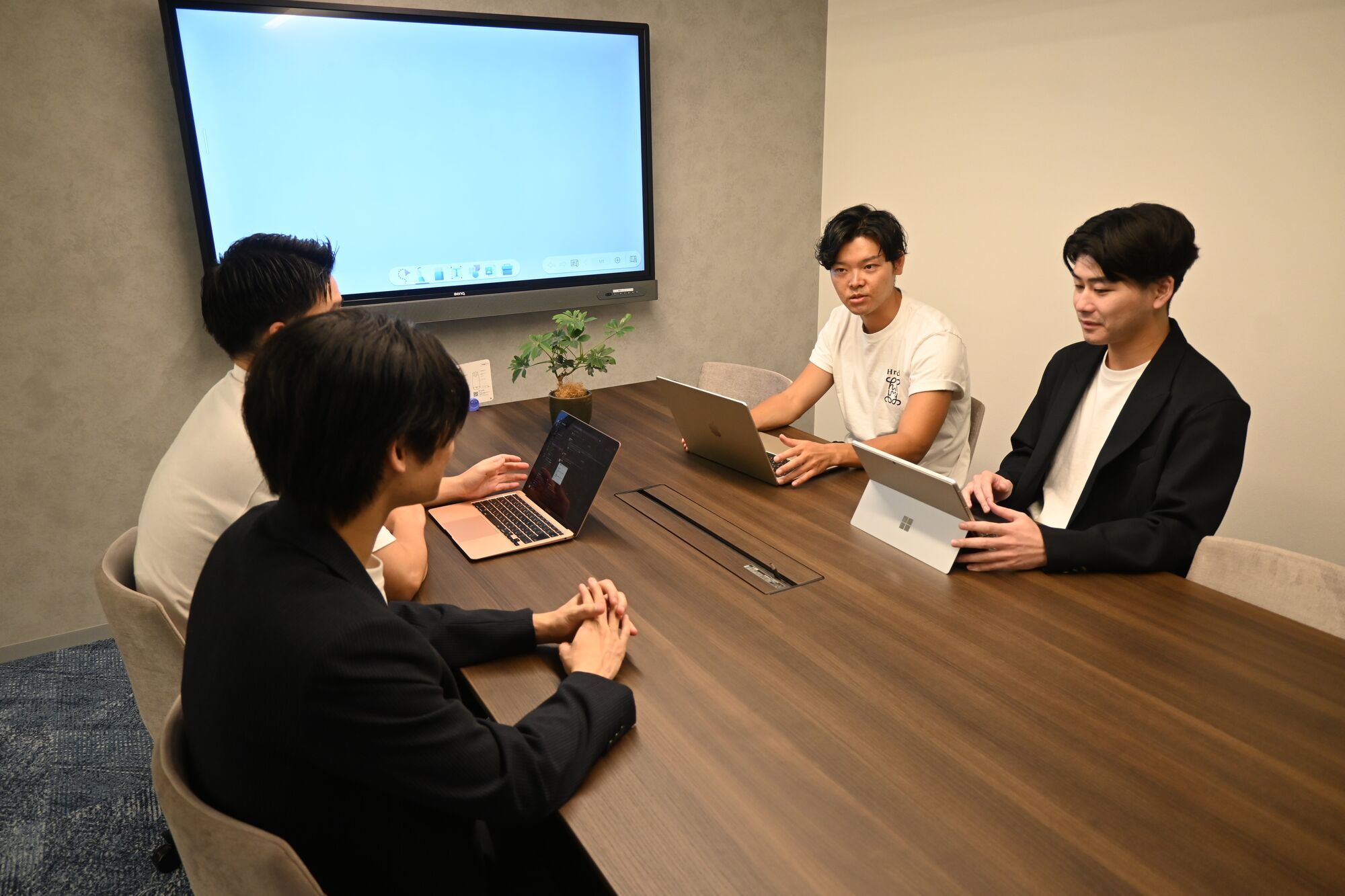 会議室で打ち合わせをするメンバー