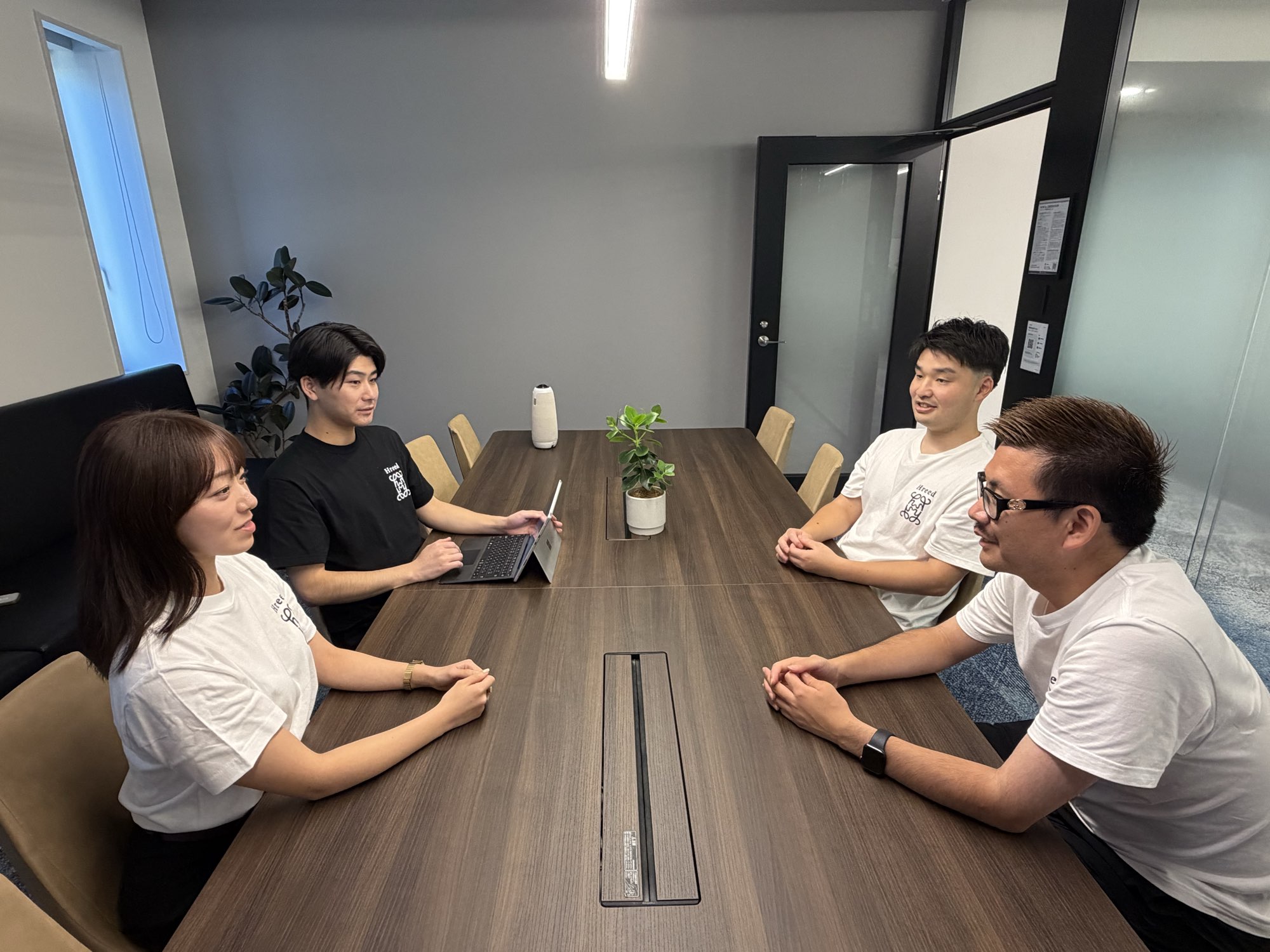 会議室のテーブルを囲んで話すHreedのメンバー
